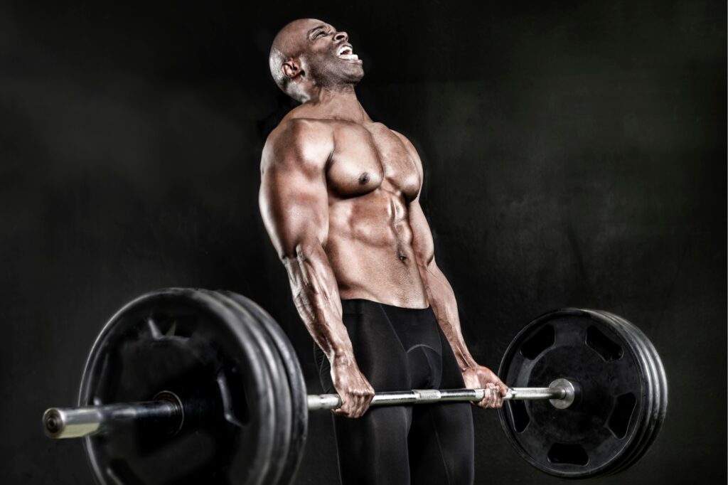 Muscular man with a straining expression performing a deadlift